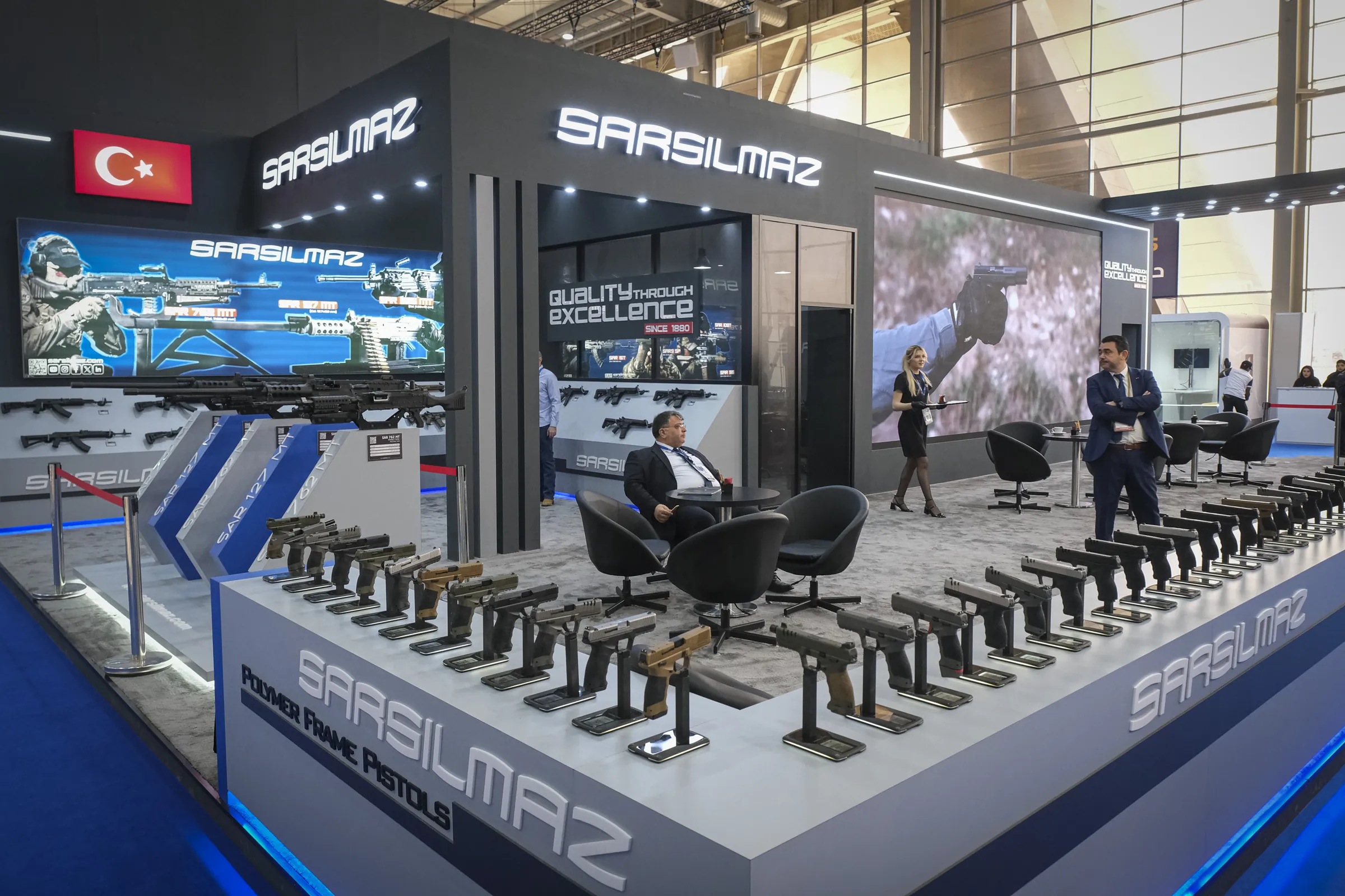 A Turkish arms manufacturer’s booth, pistols and machine guns displayed on plinths