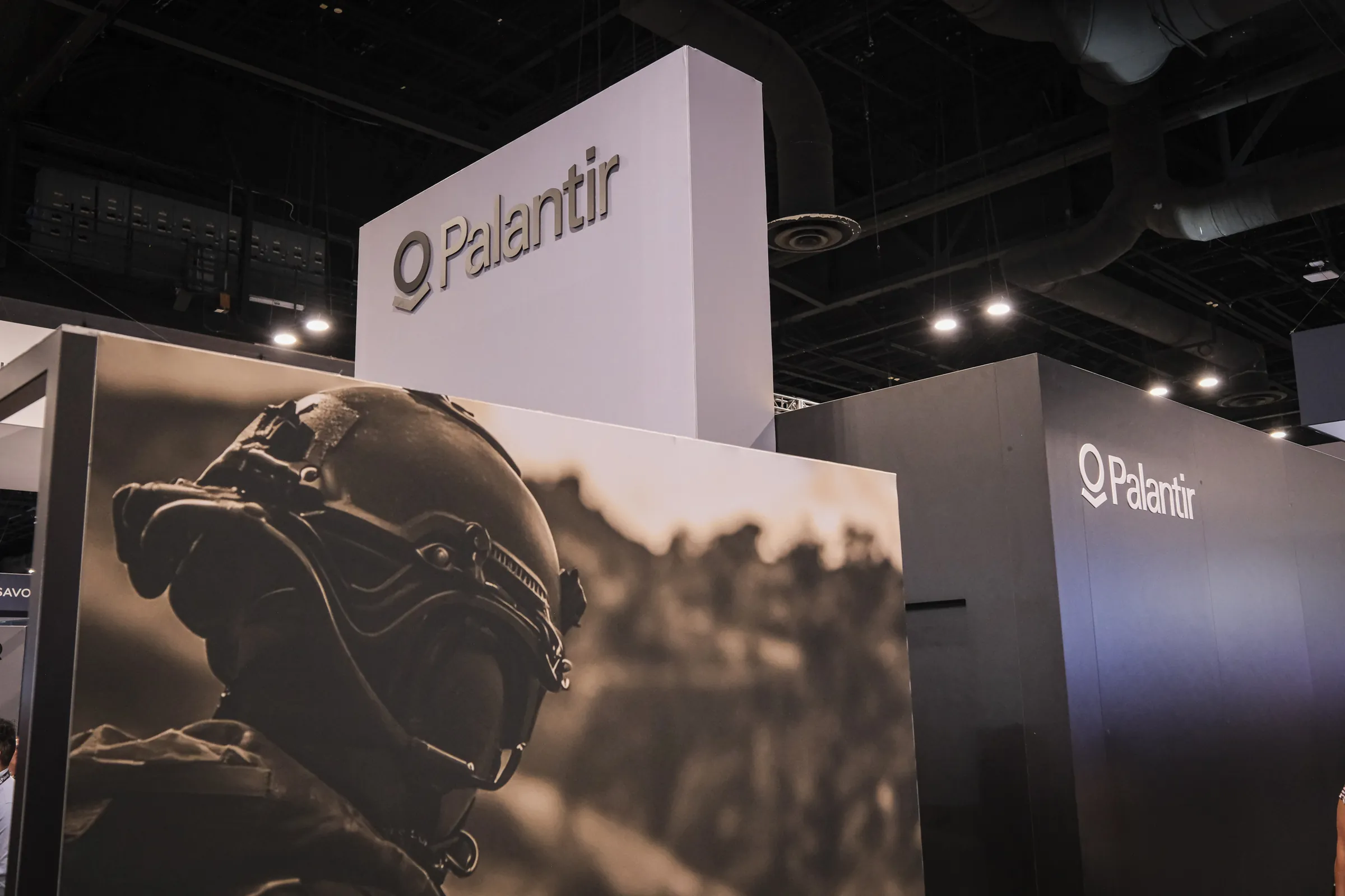 A tech company’s towering booth above a sepia mural of a special-forces soldier