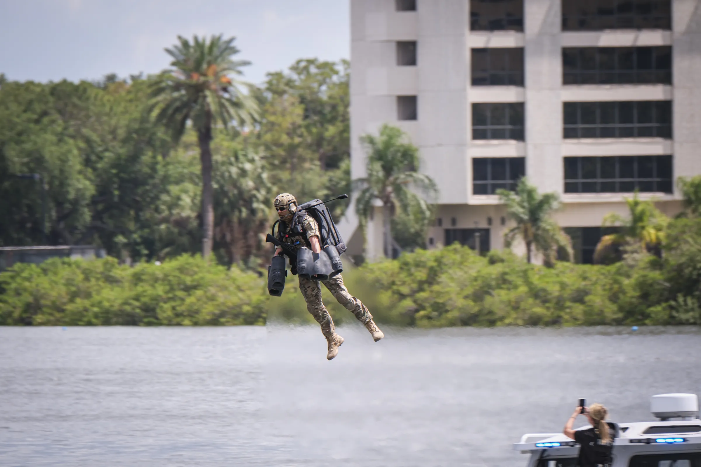 A jet-pack pilot flies low over the water during a demonstration at SOF Week in Tampa, Florida