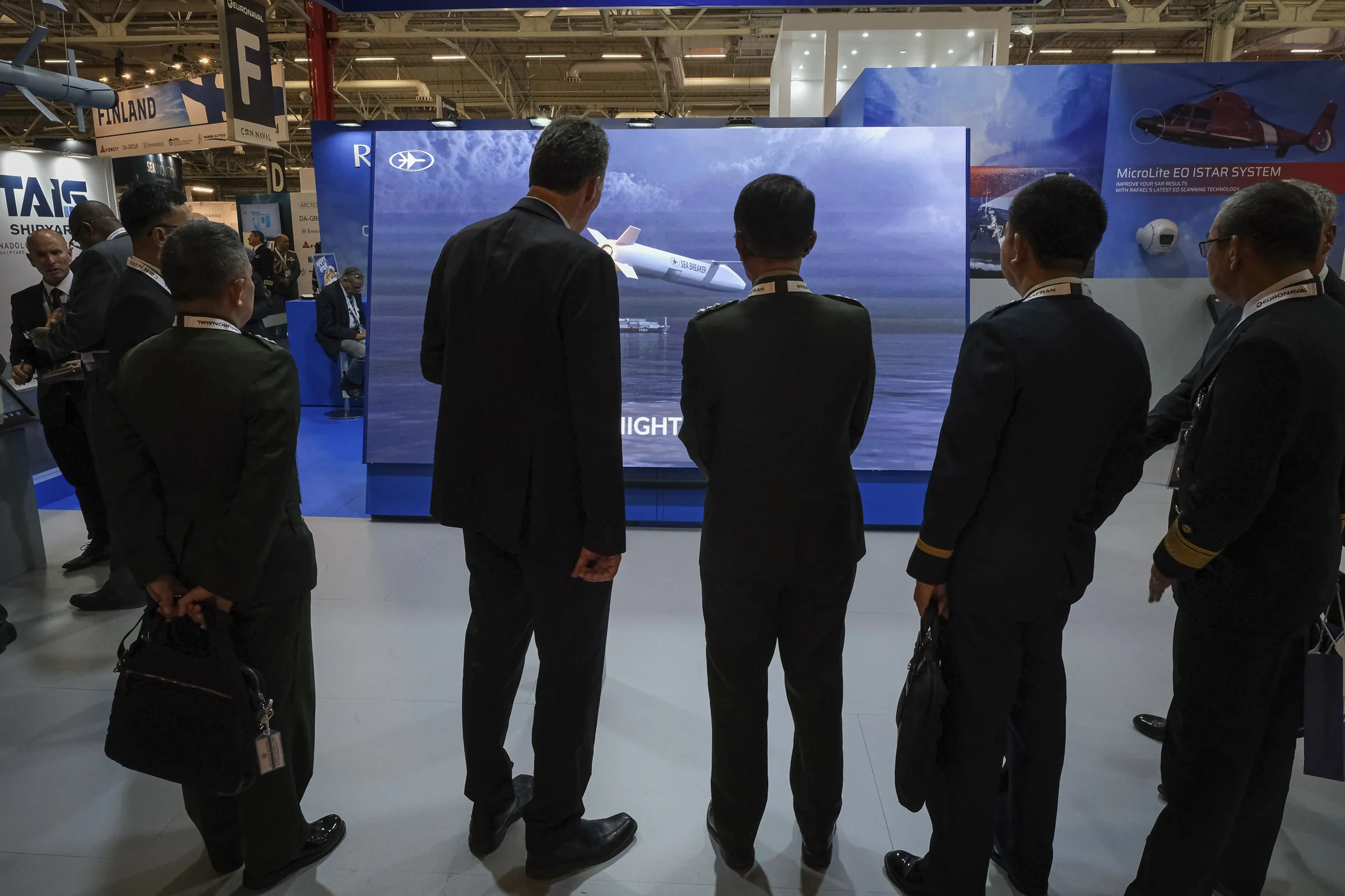 A military delegation watches a missile promotional film on a giant screen at Euronaval