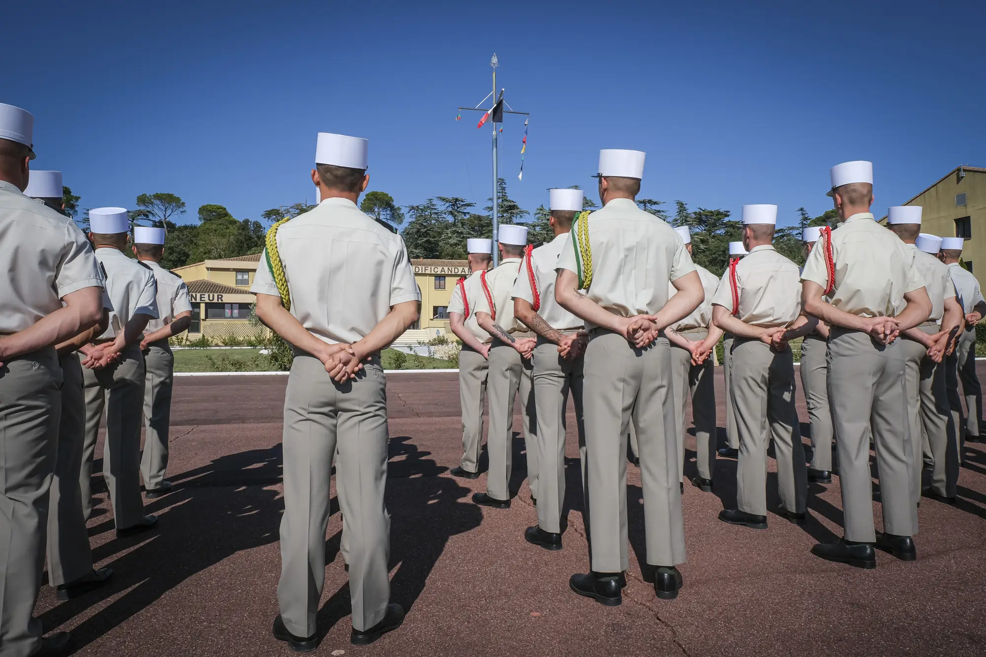 The képi blanc ceremony seen from behind ranks of white képis on the parade square