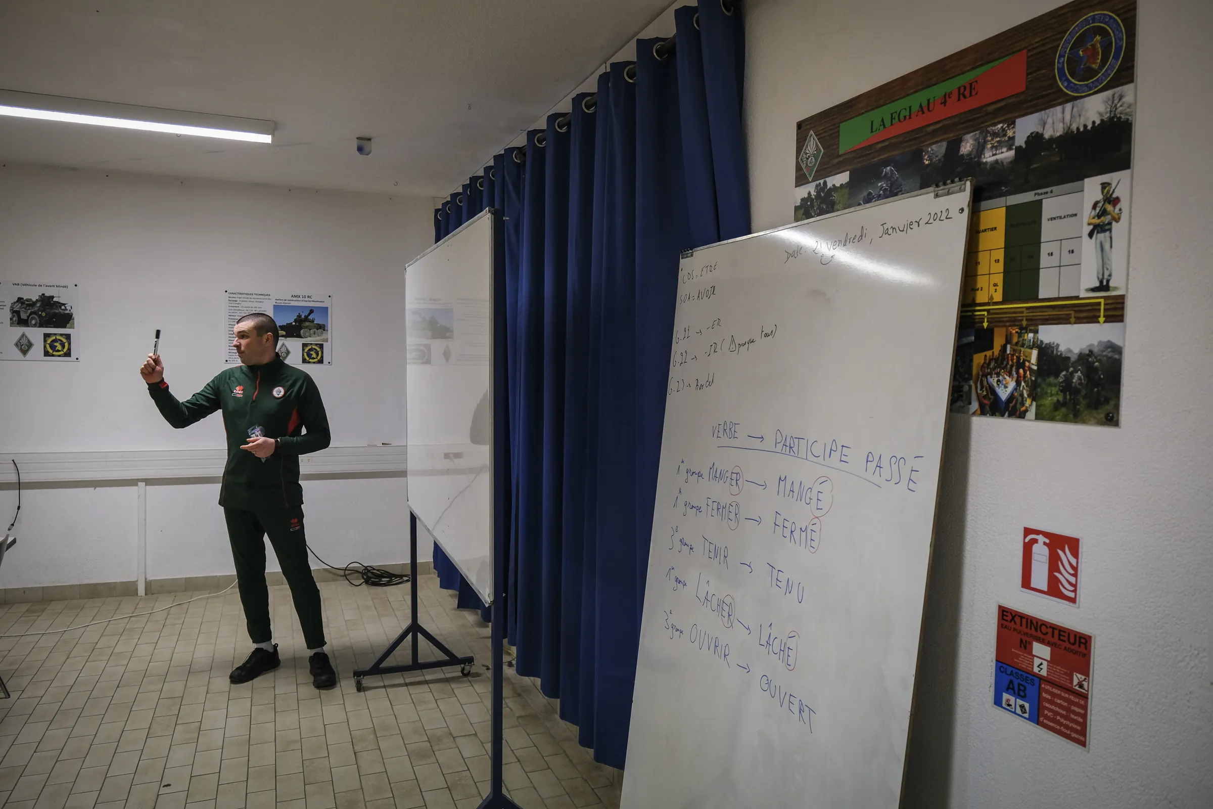 A Foreign Legion instructor teaches French grammar at a whiteboard to recruits