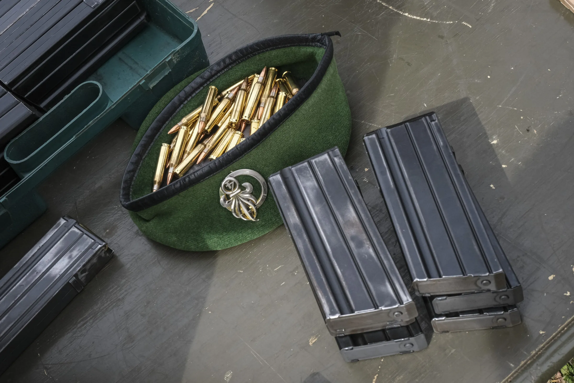 A Legion beret filled with rifle rounds beside magazines, during live-fire practice