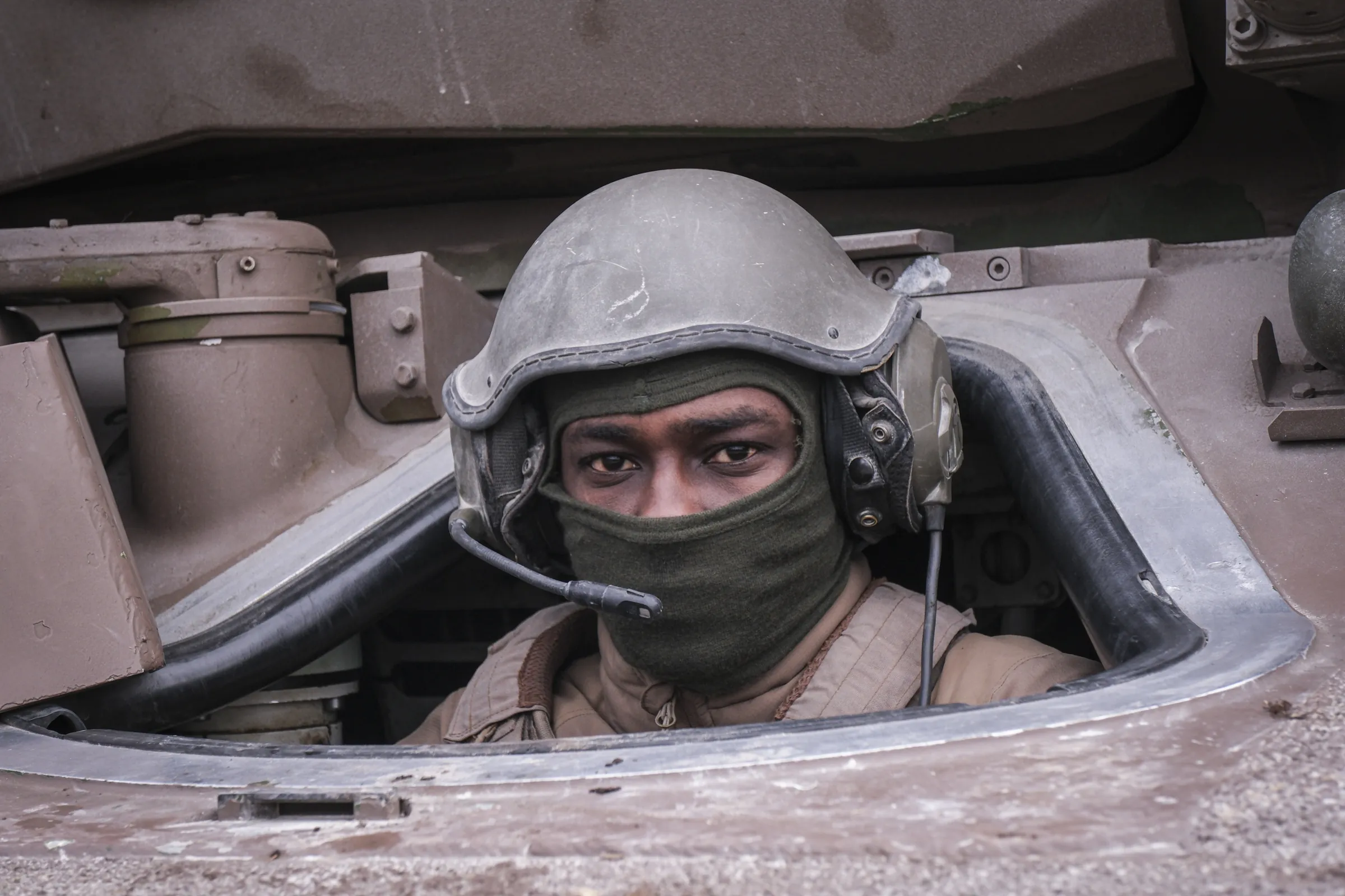 Tight portrait of a French tank driver in his hatch, steel helmet and balaclava