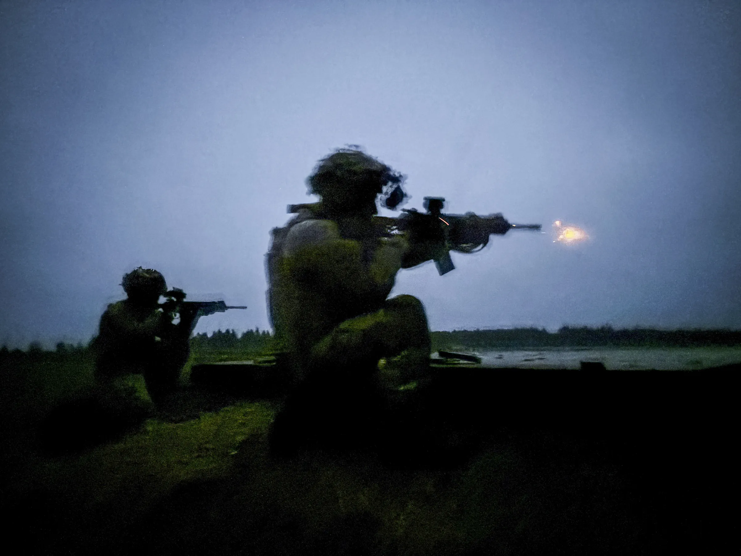 Kneeling silhouettes of soldiers during night live-fire, a muzzle flash against deep blue dusk