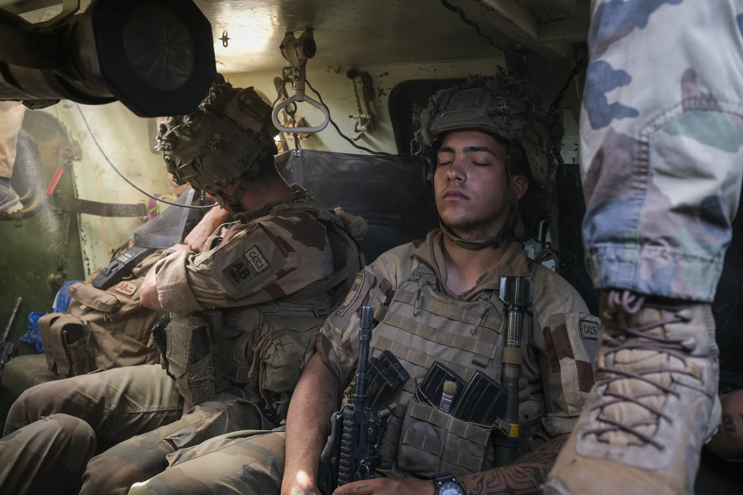 French soldiers rest inside an armoured vehicle during an operation in the Sahel, April 2021