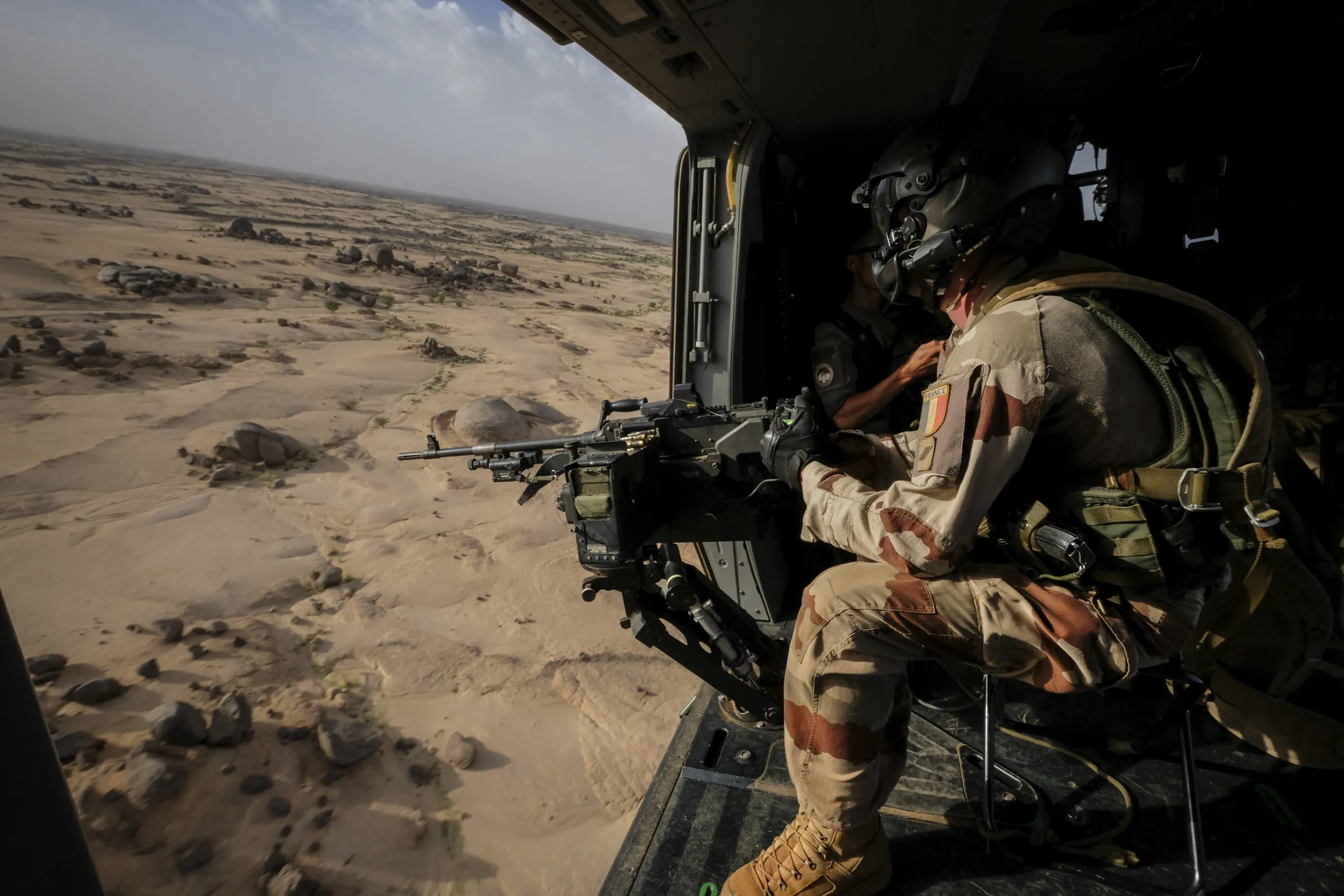 A French door gunner watches over the desert of northern Mali from a helicopter, during Barkhane Operation